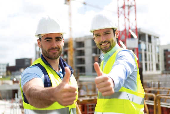 Two male construction workers thumbs up