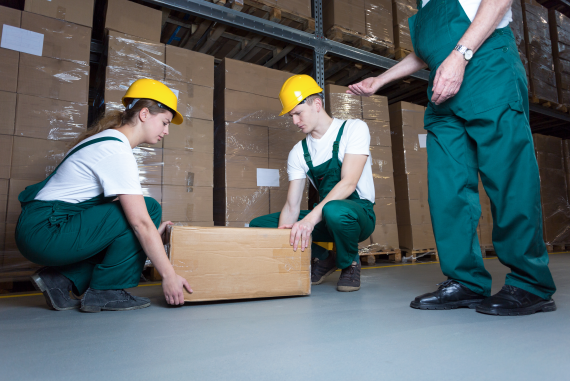 An instructor providing manual handling training in a warehouse